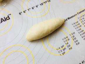 卷成橄榄型，收口留在底部。放在发酵布上，发酵一个小时