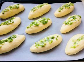 发酵完成后，中间划一道口儿，将青葱料涂上。面包摆放要有一定的间隔。