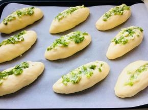 发酵完成后，中间划一道口儿，将青葱料涂上。面包摆放要有一定的间隔。