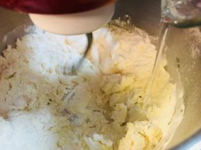 边搅拌边加入水，慢速搅打。加入新鲜酵母，慢速打成团，揉至扩展！出手摸，戳破破口呈小锯齿状。