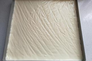 将拌好的蛋糕糊倒入方盘中，用刮刀抹平表面，或者像我一样用竹签来回划动使表面平整，然后再将方盘放入预热好的烤箱，中层上下火180度烤约25分钟（方盘预先垫上油纸或油布）