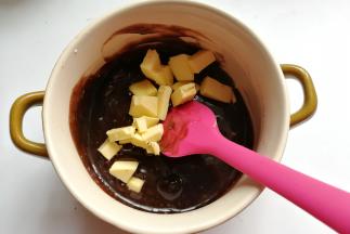 然后加入软化的黄油和少许香草精，继续搅拌混合至黄油融化