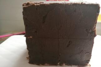 再用刮板在蛋糕体四周找出中心点，打上“十字”记号，然后先取一块翻糖方块贴在中心点，再依次围绕中心点交错着贴上各种颜色的翻糖方块