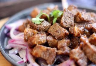 将黑胡椒牛肉粒放入步骤4提前准备好的热热的烤盘上。