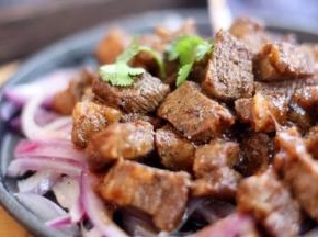 将黑胡椒牛肉粒放入步骤4提前准备好的热热的烤盘上。