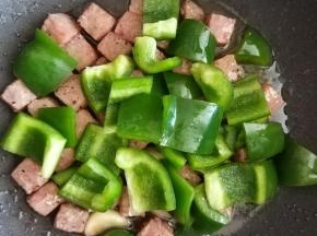 炒到牛仔粒变色时，加入青椒一起大火翻炒至熟。