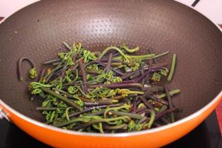 煸香蒜末，倒入蕨菜，爆炒；