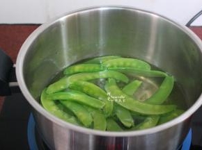 清水煮沸，放入荷兰豆，汆烫至八成熟；