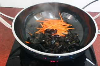 热锅，倒油，大火，放入胡萝卜丝、黑木耳爆炒至八成熟；