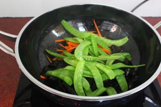 把汆烫好的荷兰豆加入，翻炒；