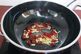 热锅，倒油，油温达200度左右，倒入干辣椒、葱白、姜末；