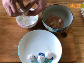 码味后，将鸡片捋直，少量粘上淀粉，然后裹成球状，再放入淀粉中将鸡球均匀的裹上淀粉，并用手将鸡球捏紧，避免下一个操作时鸡球散开