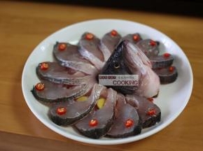 放上鱼头和鱼尾，从缝里插入姜片，摆上辣椒段