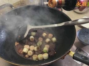 然后加入少许老抽调色，少许耗油、白糖提鲜增香，翻炒均匀