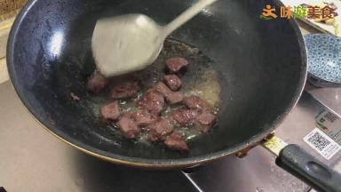 不时翻动牛肉块，并用锅铲按压，将牛肉块四面煎至微缩水盛出