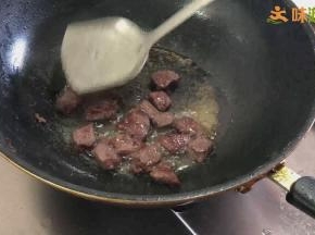 不时翻动牛肉块，并用锅铲按压，将牛肉块四面煎至微缩水盛出
