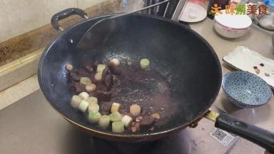 锅重新烧热，加入三分之一汤勺的油，然后放入切好的姜、蒜、洋葱，炒出香味后，再加入大葱段炒出香味，加入适量红酒，再放入煎好的牛肉块翻炒