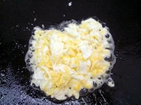 锅里油热将鸡蛋炒散