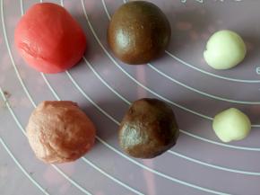 一份油皮滴一滴红色色素揉匀滚圆，一份油皮取大部分混合可可粉揉匀滚圆备用，剩下的小部分滚圆备用，油酥也同样