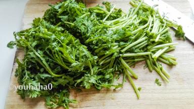 新鲜的茼蒿用淡盐水浸泡一会，冲洗干净，控干水分，切一刀成大段。