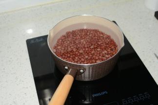 红豆表皮舒展后滤去热水，重新加入冷水，用中火煮(火太大的话会使豆粒相互撞击，碰过表皮)

