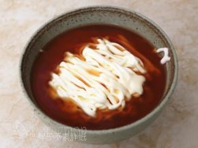 将红茶慕斯糊倒到面碗中，比面条稍微低一点的位置即可。