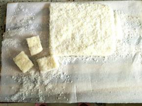 冷藏好的牛奶小方倒扣在案板上，切块裹上椰蓉即可