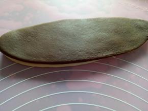 把黑色面片盖在白色面片上，用擀面杖擀薄一点