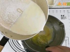 将沸腾的牛奶倒入蛋黄面糊，混合后过筛