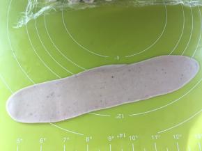 松弛好的牛舌卷再擀一次，擀成长条，这次的长度比第一次长一倍