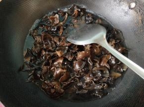 将黑木耳倒入锅内焯水。