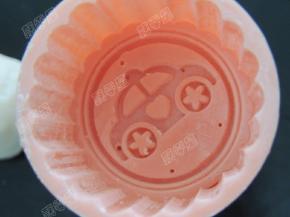 月饼模中撒一些熟糯米粉，将多余的粉抖干净