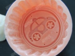 月饼模中撒一些熟糯米粉，将多余的粉抖干净