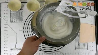 用电动打蛋器打发蛋白，中间分两次加入白砂糖，打发到打蛋器头部可以拉出小弯钩的状态
