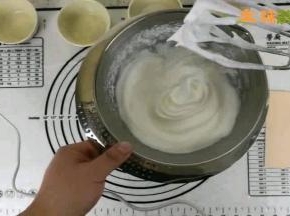 用电动打蛋器打发蛋白，中间分两次加入白砂糖，打发到打蛋器头部可以拉出小弯钩的状态