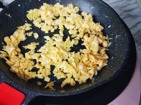 电磁炉最小火力煎蛋，待蛋液凝固后将蛋饼用铲子铲碎。
