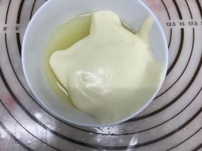 取一小部分拌好的面糊加入柠檬汁、玉米油混合物中，拌匀。