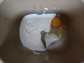 鸡蛋和酸奶加入面包机。对角放盐和糖。