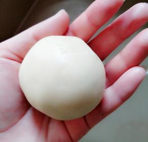 月饼皮包住豆馅，翻过来慢慢收口。