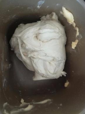 加入黄油后，要观察搅拌桶，如果边沿有黄油可以用手处理下，把黄油放在面团上，继续和面。