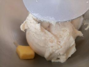 这时就可以放入盐和软化好的黄油了。继续揉。