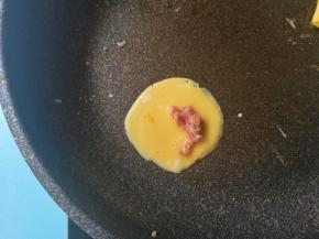 用勺子摊入蛋糊，放入肉末