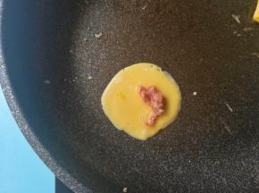 用勺子摊入蛋糊，放入肉末