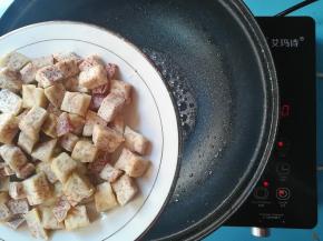 下入香芋丁，关火，离炉，搅拌，不停的搅拌出白色糖沙即可