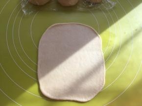 取一份松弛好的面团，用擀面杖擀成长方形，松弛好的面团在擀的过程中有轻微回弹，回弹过大证明面团没松弛好