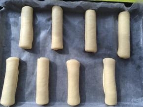 烤盘铺油纸，将卷好的面包卷摆放在烤盘内，我用烤箱自带的烤盘，不粘的，内部也很平整