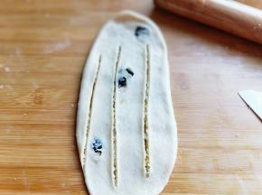 再次擀长舌状，用锋利刀划三个口子，划透，再像扭麻绳一样扭起来。