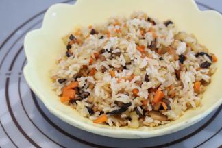 锅内倒入油，炒香香菇和虾米，放入土豆胡萝卜丁，炒熟后倒入米饭，加入配料炒好盛出