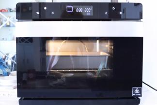 将做好的鸡翅包饭放入预热好的烤箱内，开始烘烤