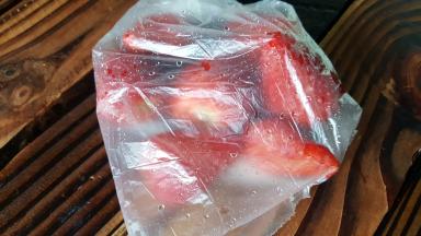 在制作冰沙前，提前将草莓洗好去蒂，放在保鲜袋中冷冻备用。